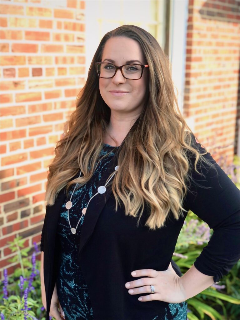 Meaghan Bain standing in front of a brick building